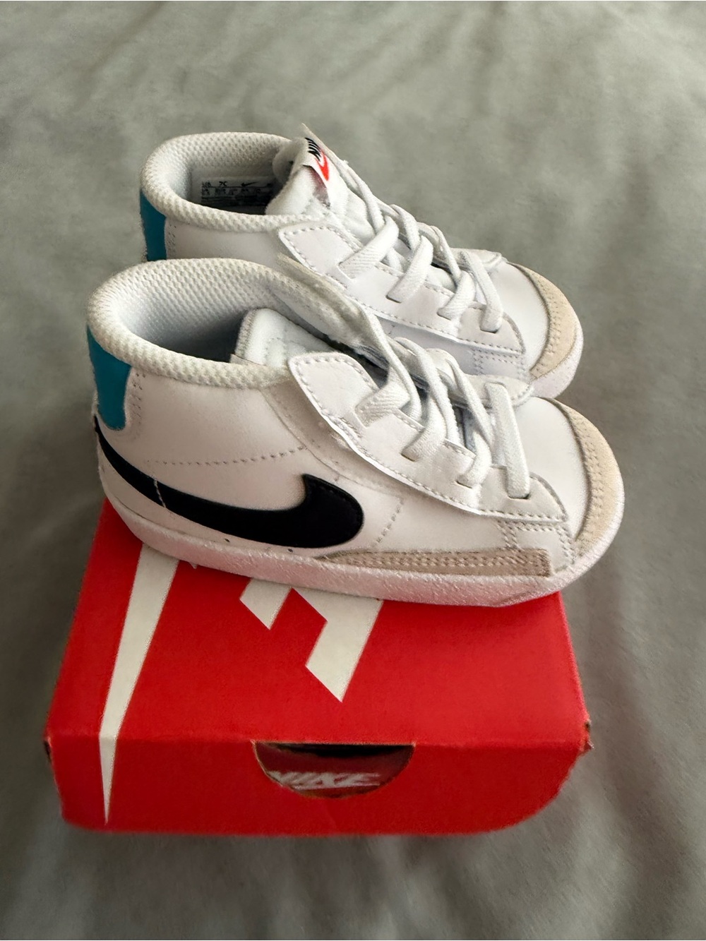 Nike Kids White Sneakers with Black Swoosh and Blue Heel Accent